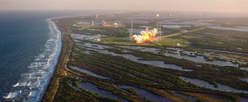 Movie still from “The Space Between Us” (2017), directed by Peter Chelsom – An aerial view of an explosion at a space shuttle launch site; Extreme Wide shot, Overhead angle