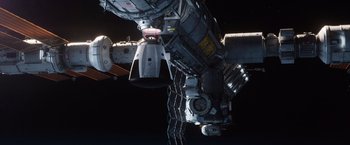 Movie still from “The Space Between Us” (2017), directed by Peter Chelsom – An image of a space station in the dark; Extreme Wide shot, Overhead angle