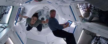 Movie still from “The Space Between Us” (2017), directed by Peter Chelsom – A man and a woman are in a space station; Medium shot, Overhead angle