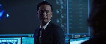 Movie still from “The Space Between Us” (2017), directed by Peter Chelsom – A man wearing a suit and tie in front of monitors; Close Up shot, Low angle