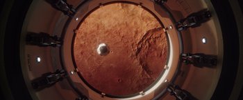 Movie still from “The Space Between Us” (2017), directed by Peter Chelsom – An overhead view of a red planet with a hole in the center; Extreme Wide shot, Overhead angle