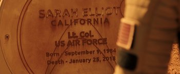 Movie still from “The Space Between Us” (2017), directed by Peter Chelsom – A memorial plaque with the name of a fallen soldier engraved on it; Extreme Close Up shot, Over the shoulder angle