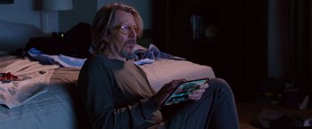 Movie still from “The Space Between Us” (2017), directed by Peter Chelsom – A man sitting on a bed looking at a tablet computer; Medium shot, Over the shoulder angle