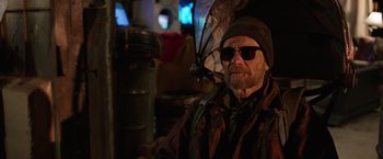 Movie still from “The Space Between Us” (2017), directed by Peter Chelsom – A man with a hat and sunglasses holding an umbrella; Close Up shot, Over the shoulder angle