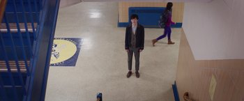 Movie still from “The Space Between Us” (2017), directed by Peter Chelsom – A man standing in the middle of a school hallway; Wide shot, High angle