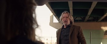 Movie still from “The Space Between Us” (2017), directed by Peter Chelsom – A man with long white hair wearing a suit and glasses; Medium shot, Over the shoulder angle