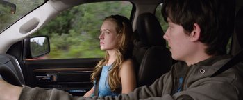 Movie still from “The Space Between Us” (2017), directed by Peter Chelsom – A girl and a boy in the back seat of a car; Medium shot, Over the shoulder angle