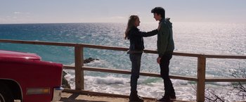 Movie still from “The Space Between Us” (2017), directed by Peter Chelsom – A man and a woman standing next to a railing near the ocean; Medium shot, Over the shoulder angle