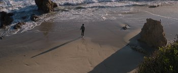 Movie still from “The Space Between Us” (2017), directed by Peter Chelsom – A man walking on the beach near the water; Extreme Wide shot, High angle