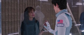 Movie still from “The Space Between Us” (2017), directed by Peter Chelsom – A woman and a boy are shaking hands through a window; Medium shot, Over the shoulder angle