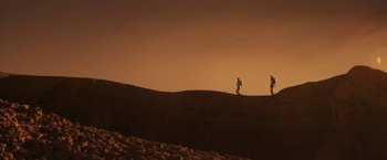Movie still from “The Space Between Us” (2017), directed by Peter Chelsom – Two people are walking on a hill at sunset; Extreme Wide shot, Low angle