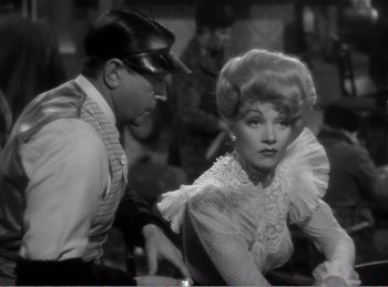 Movie still from “The Spoilers” (1942), directed by Ray Enright – A man and a woman are looking at each other; Medium shot, Over the shoulder angle