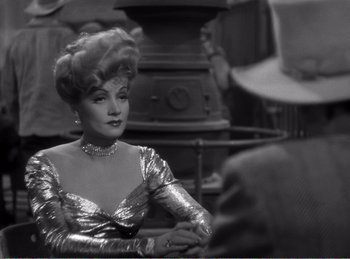 Movie still from “The Spoilers” (1942), directed by Ray Enright – An old photo of a woman in a silver dress; Close Up shot, Over the shoulder angle