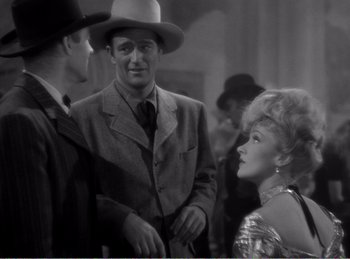 Movie still from “The Spoilers” (1942), directed by Ray Enright – A group of men standing next to each other in a room; Medium shot, Over the shoulder angle