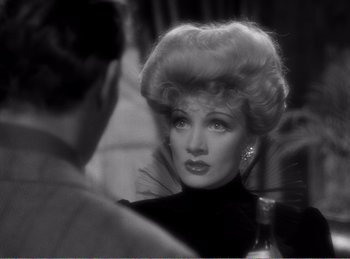 Movie still from “The Spoilers” (1942), directed by Ray Enright – An old photo of a woman in a black dress; Close Up shot, Over the shoulder angle