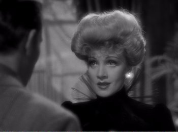 Movie still from “The Spoilers” (1942), directed by Ray Enright – An old photo of a woman in a black dress; Close Up shot, Over the shoulder angle