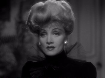 Movie still from “The Spoilers” (1942), directed by Ray Enright – A black and white photo of a woman in a black dress; Close Up shot, Over the shoulder angle