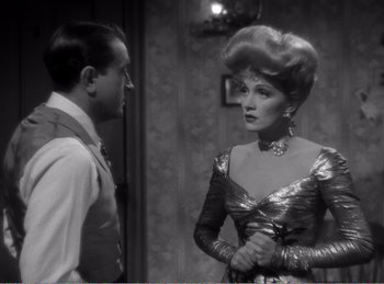 Movie still from “The Spoilers” (1942), directed by Ray Enright – A man and a woman standing next to each other in a room; Medium shot, Over the shoulder angle