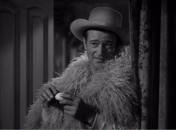 Movie still from “The Spoilers” (1942), directed by Ray Enright – A black and white photo of a man wearing a hat; Medium shot, Low angle