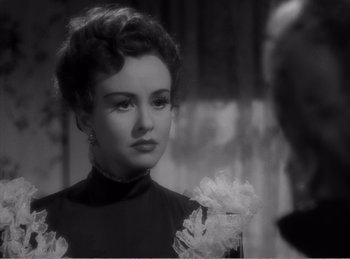 Movie still from “The Spoilers” (1942), directed by Ray Enright – An old photo of a woman in a black dress; Close Up shot, Over the shoulder angle