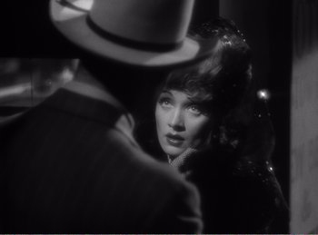 Movie still from “The Spoilers” (1942), directed by Ray Enright – A black - and - white photo of a woman and a man; Close Up shot, Over the shoulder angle