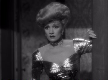 Movie still from “The Spoilers” (1942), directed by Ray Enright – A black and white photo of a woman in a silver dress; Close Up shot, Low angle