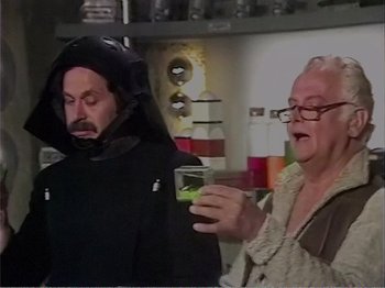 Movie still from “The Star Wars Holiday Special” (1978), directed by Steve Binder – Two people in a room holding a drink; Medium shot, Over the shoulder angle