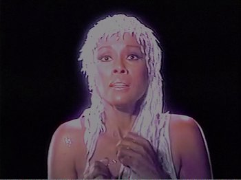 Movie still from “The Star Wars Holiday Special” (1978), directed by Steve Binder – A woman with white dreadlocks is looking at the camera; Close Up shot, High angle