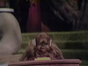 Movie still from “The Star Wars Holiday Special” (1978), directed by Steve Binder – A monkey is listening to music with headphones; Medium shot, High angle