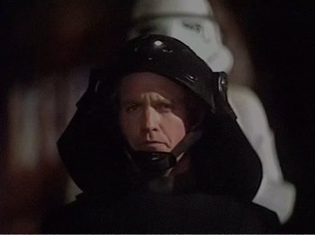 Movie still from “The Star Wars Holiday Special” (1978), directed by Steve Binder – A man wearing a helmet is looking at the camera; Close Up shot, Over the shoulder angle