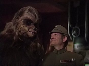 Movie still from “The Star Wars Holiday Special” (1978), directed by Steve Binder – A man in a military uniform and a wookiee; Close Up shot, Over the shoulder angle