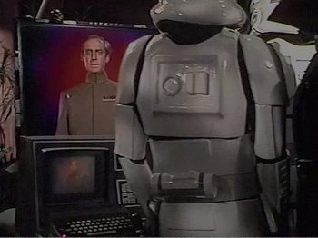 Movie still from “The Star Wars Holiday Special” (1978), directed by Steve Binder – An image of a robot in front of a television; Medium shot, Over the shoulder angle