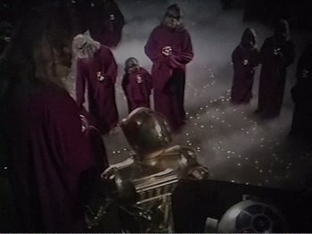 Movie still from “The Star Wars Holiday Special” (1978), directed by Steve Binder – A group of people dressed in red and black costumes; Wide shot, High angle