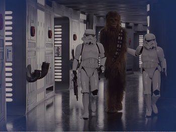 Movie still from “The Star Wars Holiday Special” (1978), directed by Steve Binder – A group of star wars characters walking down a hallway; Wide shot, Over the shoulder angle