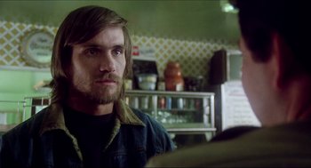 Movie still from “The Stunt Man” (1980), directed by Richard Rush – A person with a beard in a room; Close Up shot, Over the shoulder angle