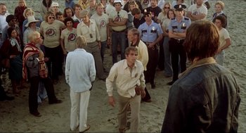 Movie still from “The Stunt Man” (1980), directed by Richard Rush – A group of people standing in a crowd of people; Wide shot, High angle
