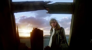 Movie still from “The Stunt Man” (1980), directed by Richard Rush – A man standing on top of a boat in the water; Medium shot, Low angle