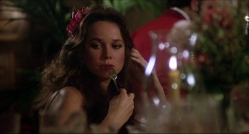 Movie still from “The Stunt Man” (1980), directed by Richard Rush – A woman sitting at a table with a fork in her mouth; Close Up shot, Over the shoulder angle