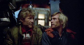 Movie still from “The Stunt Man” (1980), directed by Richard Rush – Two men standing next to each other on a bus; Close Up shot, Low angle