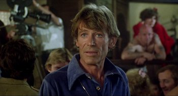 Movie still from “The Stunt Man” (1980), directed by Richard Rush – A person wearing a blue shirt; Close Up shot, Over the shoulder angle
