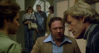 Movie still from “The Stunt Man” (1980), directed by Richard Rush – Two men and two women in a room; Medium shot, Over the shoulder angle