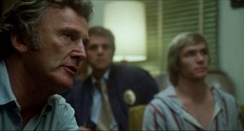 Movie still from “The Stunt Man” (1980), directed by Richard Rush – A man and two women are sitting in a room together; Close Up shot, Over the shoulder angle