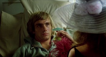 Movie still from “The Stunt Man” (1980), directed by Richard Rush – A man laying in a bed holding a green umbrella; Close Up shot, Over the shoulder angle