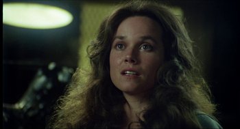 Movie still from “The Stunt Man” (1980), directed by Richard Rush – A person with long curly hair; Close Up shot, Over the shoulder angle