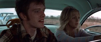 Movie still from “The Sugarland Express” (1974), directed by Steven Spielberg – A man and a woman sitting in the back of a car; Close Up shot, Over the shoulder angle