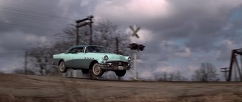 Movie still from “The Sugarland Express” (1974), directed by Steven Spielberg – An old car is flying through the air; Wide shot, Low angle