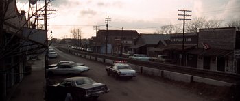 Movie still from “The Sugarland Express” (1974), directed by Steven Spielberg – A police car is driving down the street; Extreme Wide shot, High angle