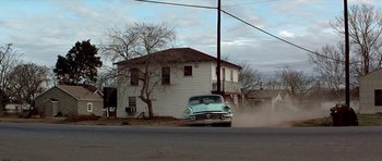 Movie still from “The Sugarland Express” (1974), directed by Steven Spielberg – An old car parked on the side of the road; Wide shot, Low angle