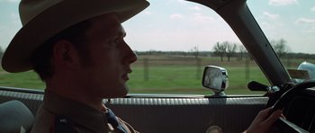 Movie still from “The Sugarland Express” (1974), directed by Steven Spielberg – A man wearing a cowboy hat looking out the window of a car; Close Up shot, Over the shoulder angle