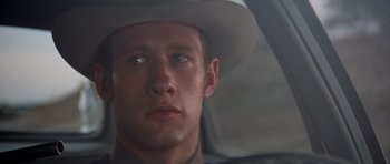 Movie still from “The Sugarland Express” (1974), directed by Steven Spielberg – A person wearing a cowboy hat; Close Up shot, Over the shoulder angle
